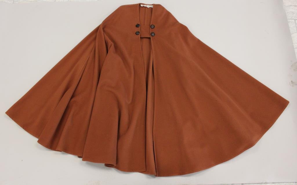 VINTAGE SAINT LAURENT PARIS RUST WOOL CAPE: Vintage, Made in France. Size: 36 Length: 42.5" Condition: Good, used condition. One button missing its wood piece. Two red 1" pen marks on front. Unlaundered. From a Port Chester, NY Estate.