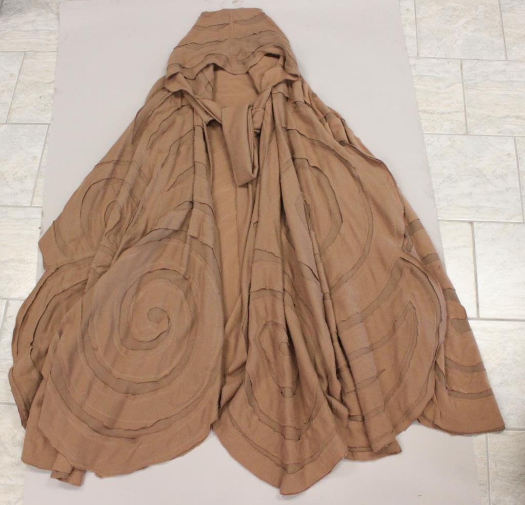ORIGINAL DESIGNER TAN APPLIQUE WOOL CAPE: No designer label. Deconstructed, applique design. Hooded with tie in front. Size: Length: 50" (not including hood) Condition: Used, no staining some light moth marks. From a Port Chester, NY Estate.