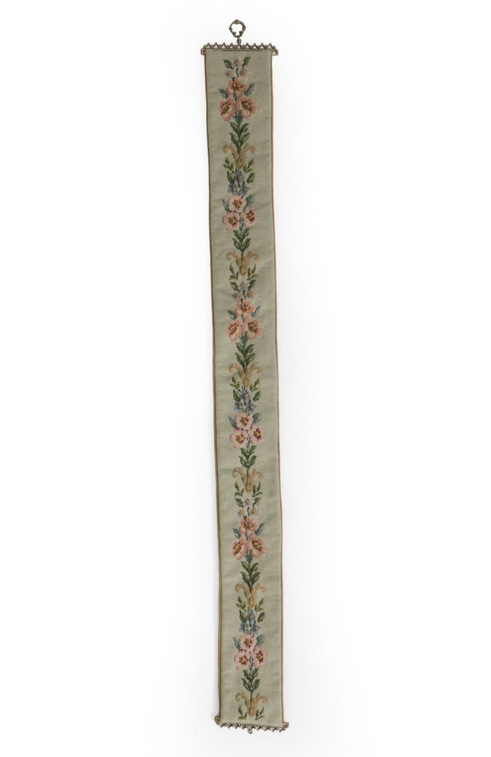VINTAGE NEEDLEPOINT BUTLERS BELL PULL TAPESTRY: Features decorative brass hardware. Dimensions: H 70.5" x W 7.5" Condition: Wear consistent with age and use. Fading, discoloration.