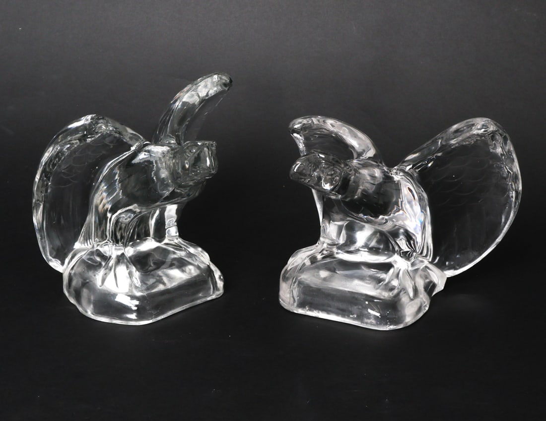 PAIR OF CAMBRIDGE GLASS EAGLE BOOKENDS: Pair of glass eagles with pontil scars on base. Apparently unmarked. Circa 1960s. Dimensions: H 5.5 " x W 7" x D 6" Condition: Wear consistent with age and use. Chips and fleabites to base.