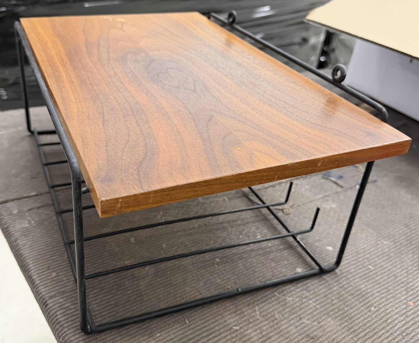 MID-CENTURY TEAK & WIRE TELEPHONE SHELF: Rectangular teak top mounted to a black wire framework with open lower storage basket. Apparently unmarked. Scandinavian, circa 1960s. Dimensions: H 8" x W 16.25" x D 10.75" Condition: Fading and disc