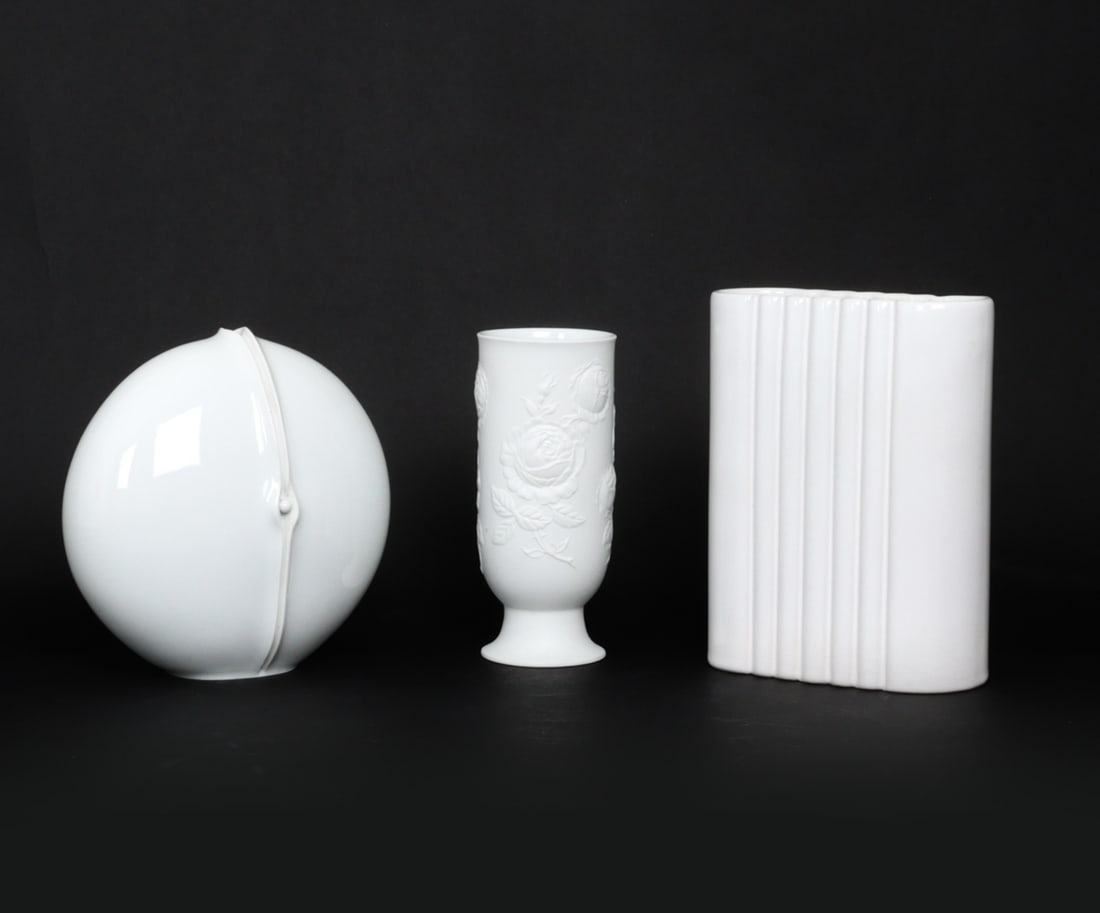GERMAN PORCELAIN GROUPING INCL. HUTSCHENREUTHER: (3) Vases including Hutschenreuther and Kaiser. Marked underneath. Dimensions: (Largest) H8.5" x W 6.5" x D 2.5" Condition: Wear consistent with age and use. Some soiling inside the vases. Scuffs, min