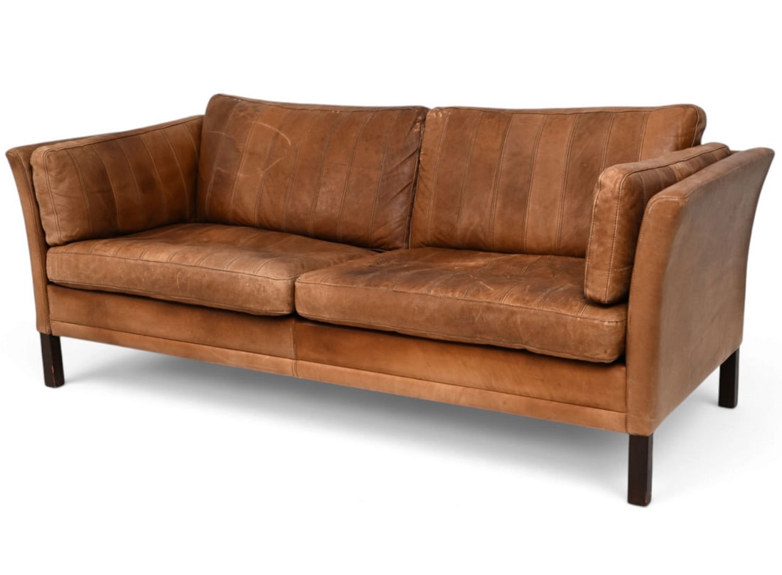 ATTR. MOGENS HANSEN DANISH LEATHER SOFA C. 1970S: Apparently unmarked. Denmark. Circa, 1970s. Dimensions: H 29.5" x W 74" x D 30" Condition: Scuffs and scratches with some creasing and discoloration to leather. Some cracking to leather cushion. Wear 