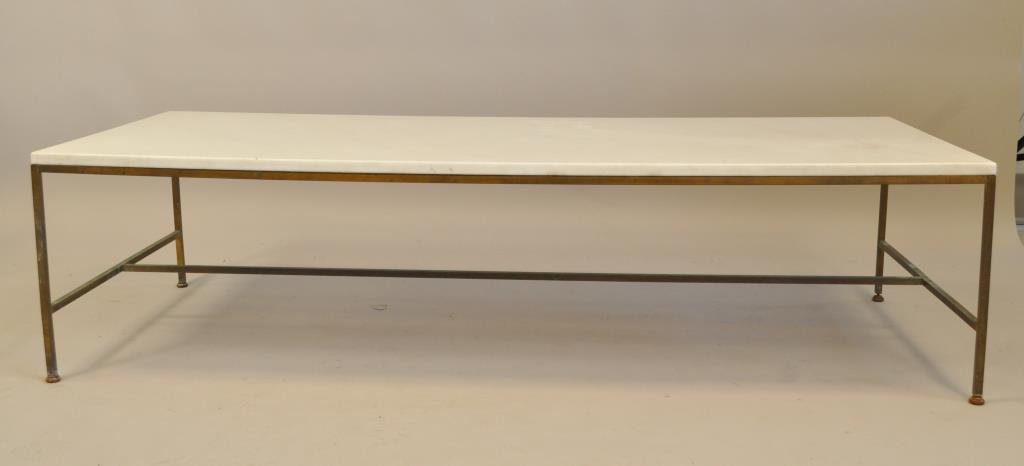 PAUL MCCOBB MARBLE TOP COFFEE TABLE: Brass base with a white marble top Dimensions: L 60" x W 24" x H 15" Condition: overall good condition, some wear to brass and rust to feet Provenance: From a Westport, CT Estate.