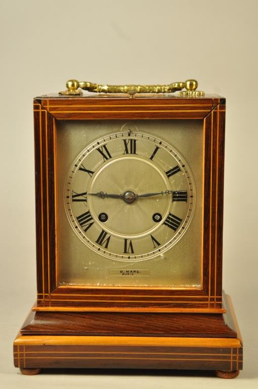 H. MARC INLAID SHELF CLOCK: Marked to clock face Dimensions: L 6" x W 5" x H 7 3/4" Condition: loss of veneer to bottom skirting, handle brackets are loose, chip to wood on back panel Provenance: From a Redding, CT Estate.