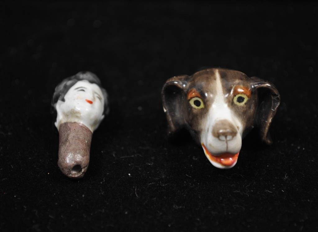 2 PORCELAIN ROYAL WORCESTER DOG WHISTLES: In the shape of a hunting dog and a Asian woman's head. Dimension: Dog: 2" Woman's head: 1.5" Condition: Good Provenance: From the Estate Antique collection of Arthur + Joe Robinson
