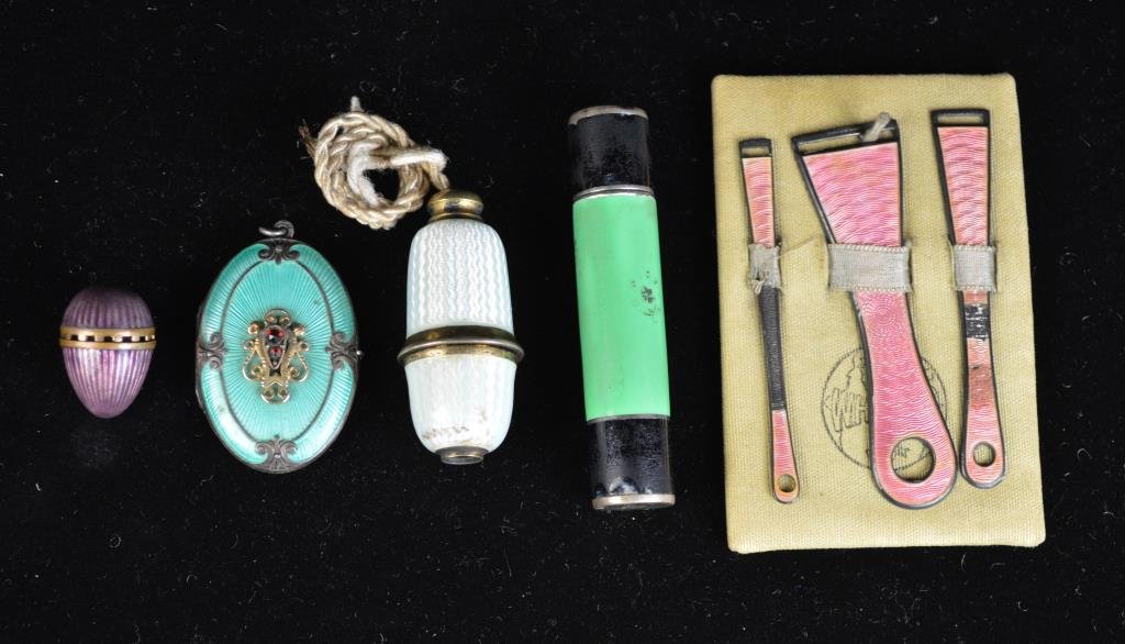 GROUPING OF GUILLOCHE ENAMEL ITEMS: Green travel manicure kit, Sterling and pink set, sterling and green locket, purple perfume egg, White butler call button. Condition: Good. Green set has chips, locket has ding on back Dimension: Pink