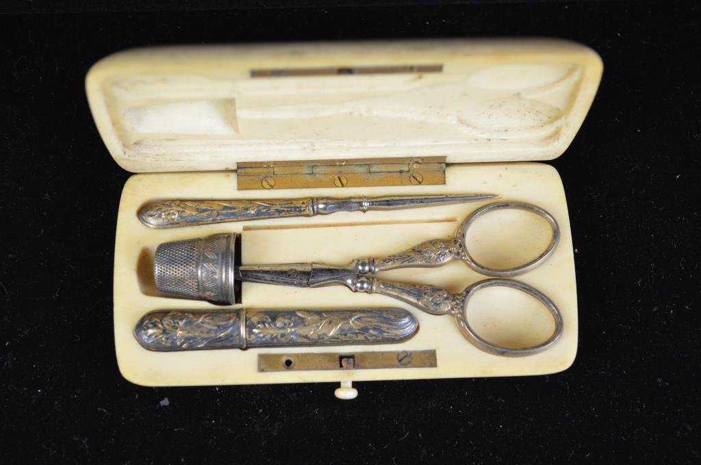 ART NOUVEAU IVORY & SILVER TRAVEL SEWING KIT: Gold vermeil, 800 silver thimble, Needle case with hallmarks. Dimension: Case: 4.25" X 2" Condition: Scissors broken, thimble not original to set. Case is excellent, missing a small plaque on front. P