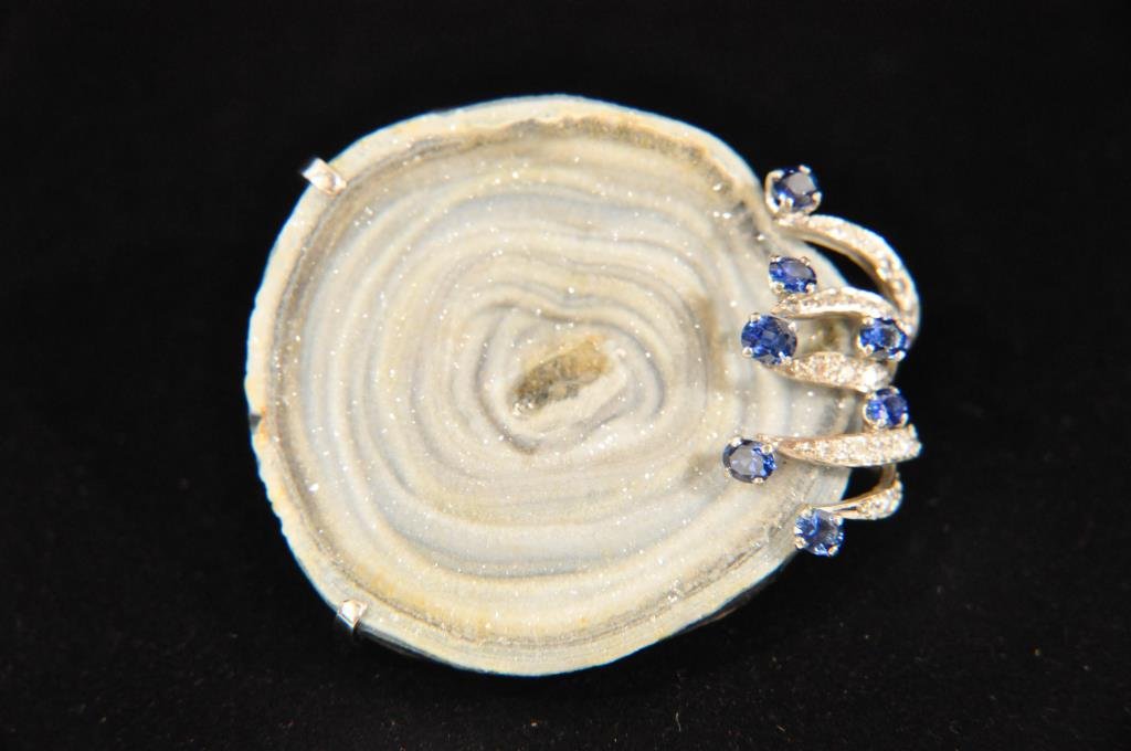 ANDREW GRIMA GEODE W DIAMOND SAPPHIRE BROOCH: Modernist brooch attributed to Andrew Grima (British, 1921-2007). Hallmarked: HJCo with English gold hallmarks. Geode with diamond and sapphire accents. Two tone 18k gold metal. This was most likely a