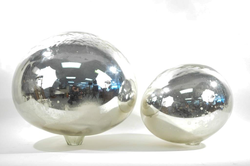 PAIR OF MERCURY GLASS GAZING BALLS: Dimension: Larger: 16" Smaller: 12" Condition: Chips along rough opening.
