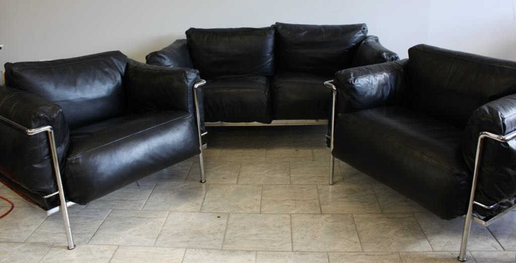 LE CORBUSIER LC3 GRAND CONFORT STYLE SEATING SET: Set includes a love seat and 2 individual chairs in black leather, unmarked Dimensions (sofa): H 30" x W 67" x D 29" Dimensions (chair): H 31" x W 39" x D 29" Condition: All pieces in very good condit