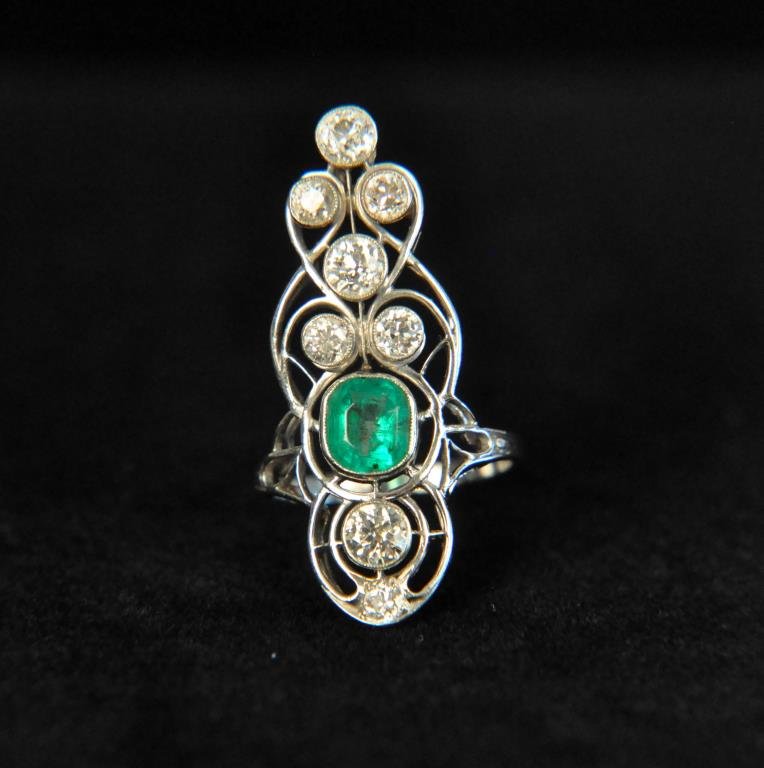 EDWARDIAN PLATINUM EMERALD & DIAMOND RING: 8 diamonds and 1 center emerald. Dimension: Face: 36mm X 16mm Emerald: 7.5mm X 7mm Total weight: 4.7dwt Condition: Very good