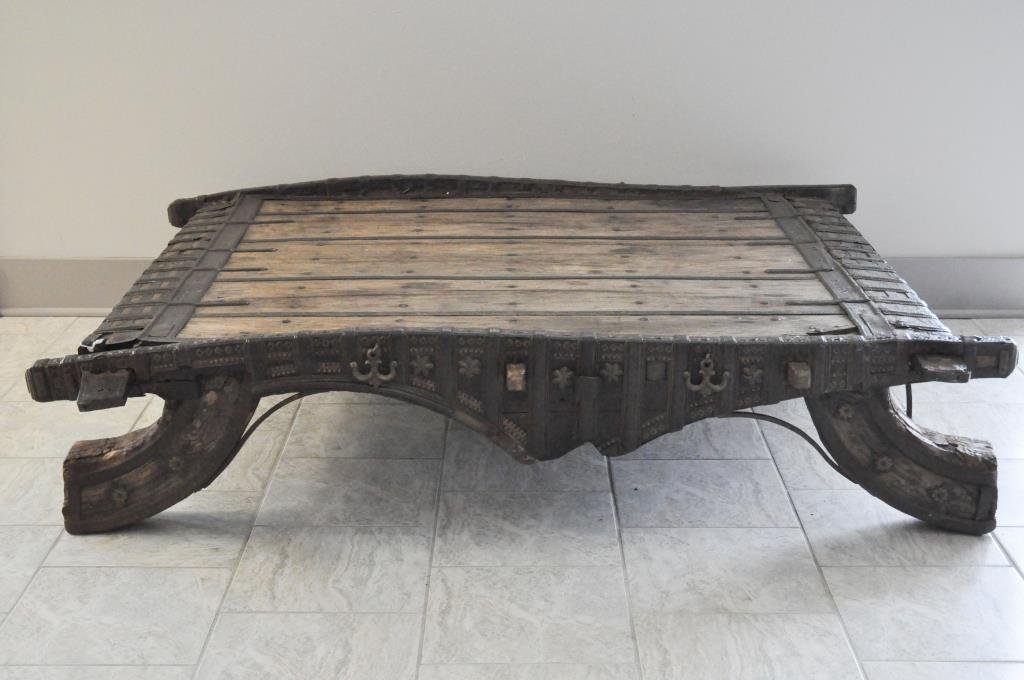 ANTIQUE ORIENTALIST TABLE: With hammered brass trim and iron hardware, possibly an old elephant saddleDimensions:H 14" x W 62" x D 53"Condition: good, some deterioration to wood, some hardware is loose