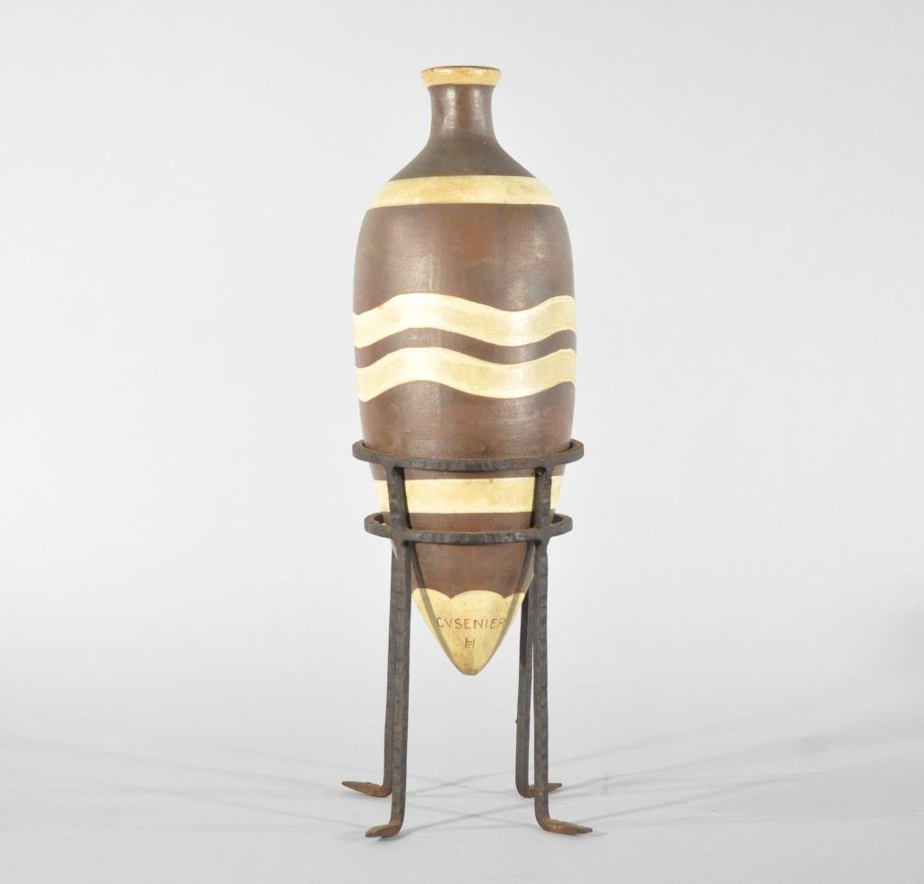RENE HERBST CUSENIER DECANTER: A ceramic wine amphora with wrought iron stand for the 1927 exposition, circa 1927, marked to base of ceramic pieceDimensions: H 14" x Diameter 5"Condition: good, missing stopper