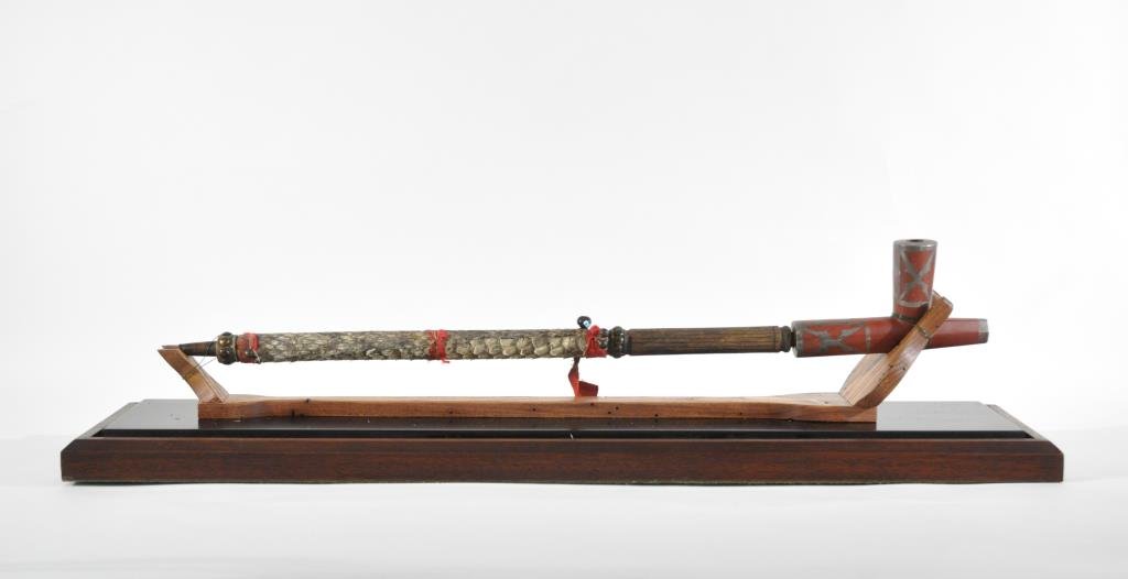RARE COMANCHE NATIVE AMERICAN PEACE PIPE: Given to John M. Taylor from Comanche Chief Quanah Parker. The pipe bowl is made of catlinite with pewter inlays. The hand carved wood stem with snake symbols is 21.5" long adorned with brass tacks an