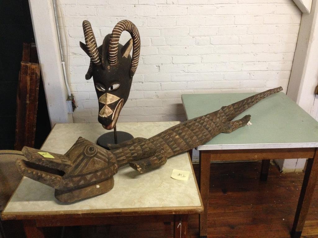 TWO CARVED WOODEN AFRICAN MASKS: Dimensions: Gator: H 71" x W 9" Head: H 24.75" x W 11" x D 14.5"Condition: fairONSITE WAREHOUSE AUCTION, ITEMS MUST BE PICKED UP WITHIN 7 DAYS AFTER THE AUCTION, ALL ITEMS LEFT PAST THAT DAY WILL BE A