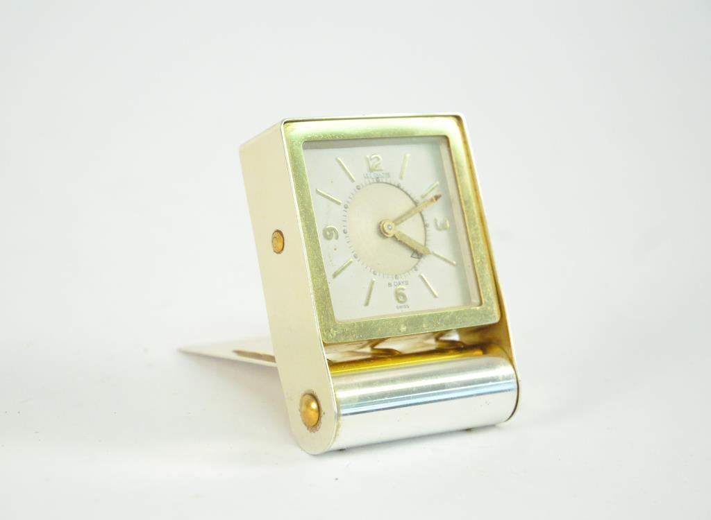 1960S LE COULTRE 8 DAY TRAVEL ALARM CLOCK: Chrome and gold. Dimensions: H 3" X W 3.25" X D 0.75"Condition: Good, runs but keeps slow time.
