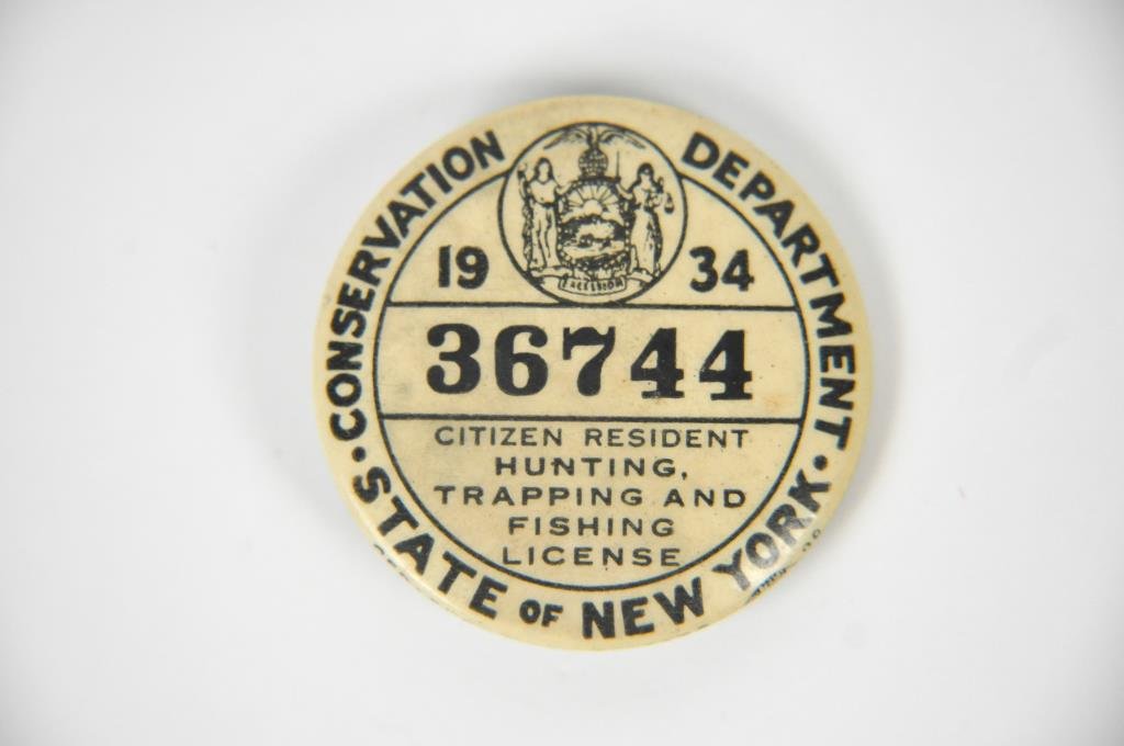 1934 NY RESIDENT FISHING & HUNTING LICENSE: State of New York Conservation Department. 1934. 36744. Citizen resident hunting, trapping, and fishing license. Dimensions: dia 1.75"Condition: some discoloration to button, some rust to back