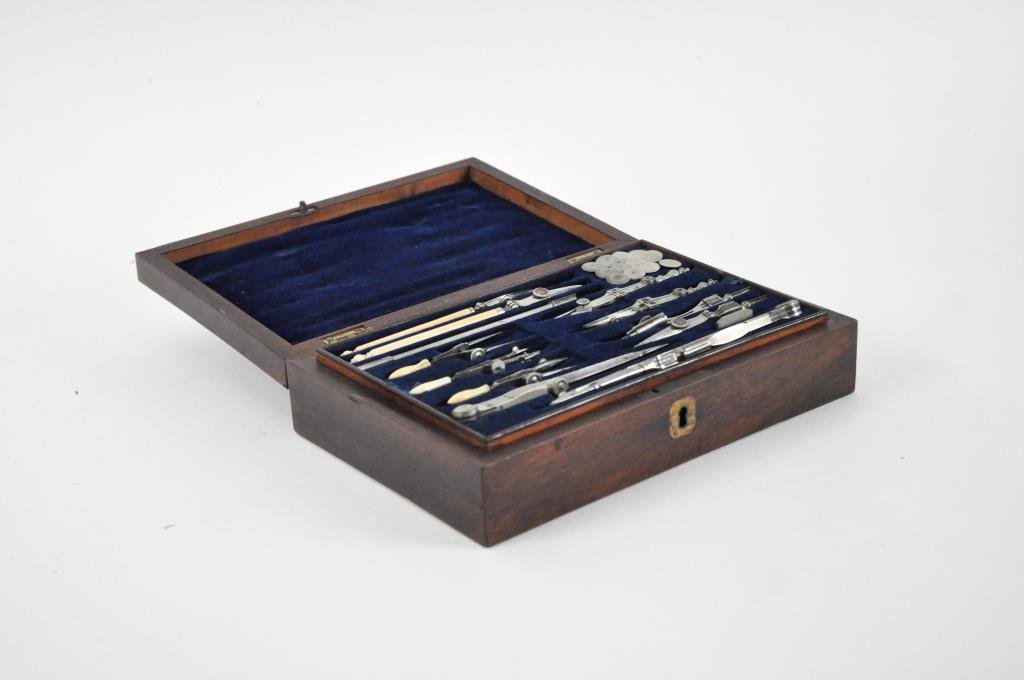 19TH C. DRAFTING SET: In a wood box with brass inlay, velvet lined inside featuring two levels of tools and stamps Dimensions: H 2.5" x W 9.5" x D 6.5" Condition: good