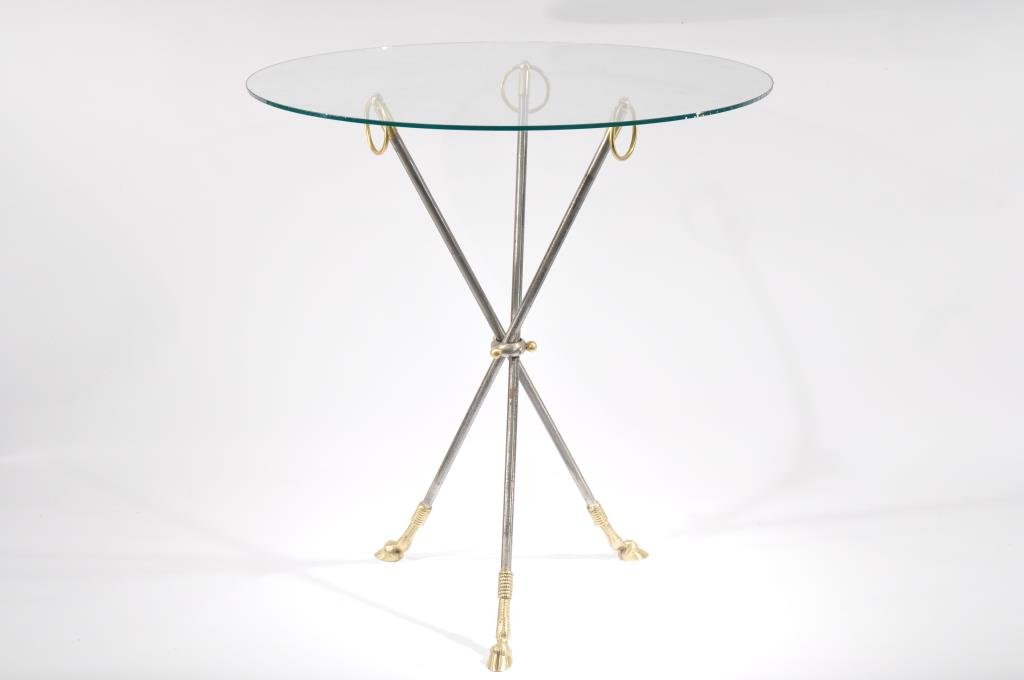 SIDE TABLE IN THE STYLE OF MAISON JANSEN: Tri-ped with hooved feet, steel and brass Dimensions: H 28" x D 26" Condition: Oxidation to steel.