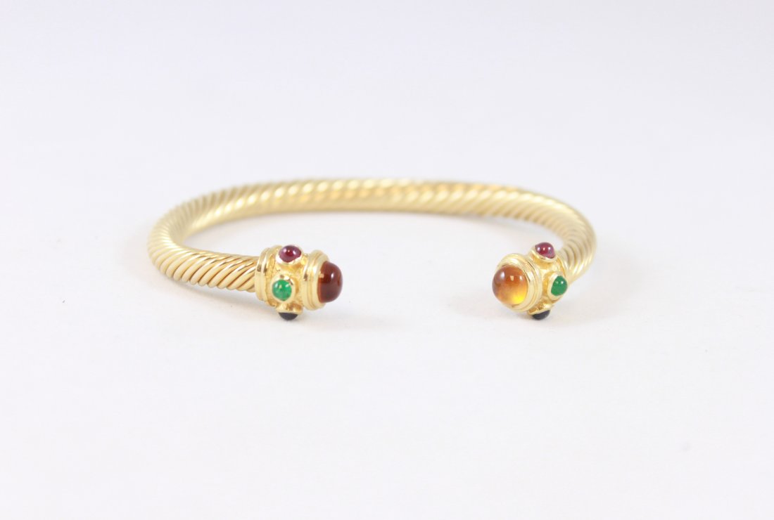 14K GOLD BANGLE WITH RUBY, EMERALD AND SAPPHIRE: David Yurman Style. 14k twisted gold with ruby, emerald , sapphire and citrine cabochons. Dimensions: 2.75" x 2.25" Total Weight: 16.7 gCondition: Good