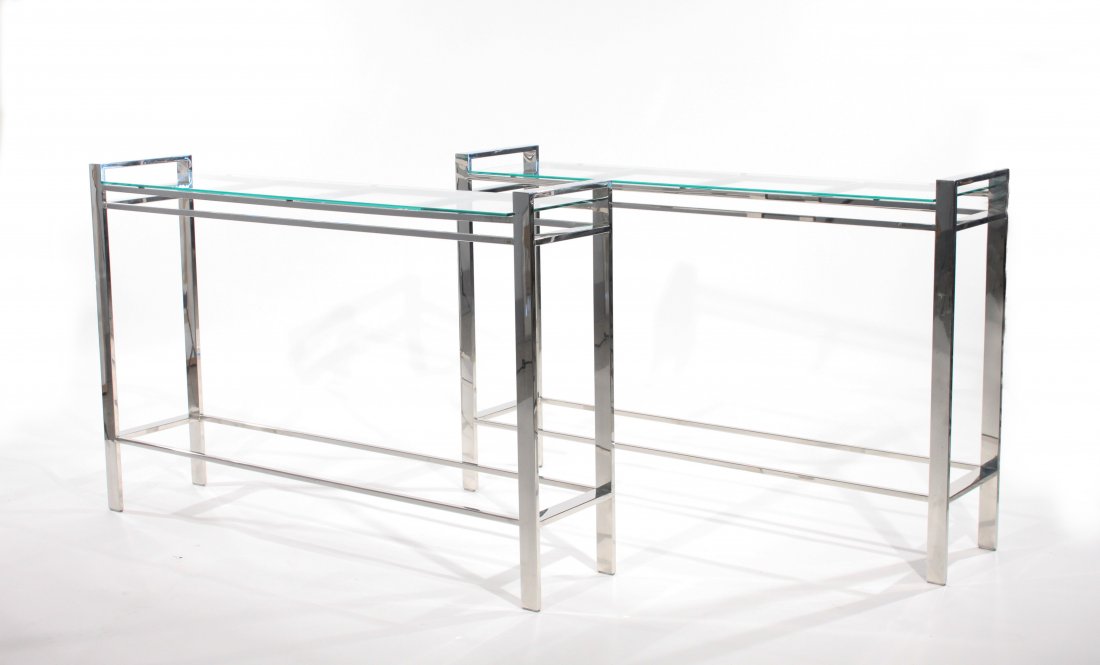 STYLE OF MILO BAUGHMAN, TWO CONSOLE TABLES: USA, 1970s, chromed steel and glass, unsignedDimensions: H 30" x W 46" x D 10"Condition: Chromed is clean and bright. New glass shelves. Very good condition.