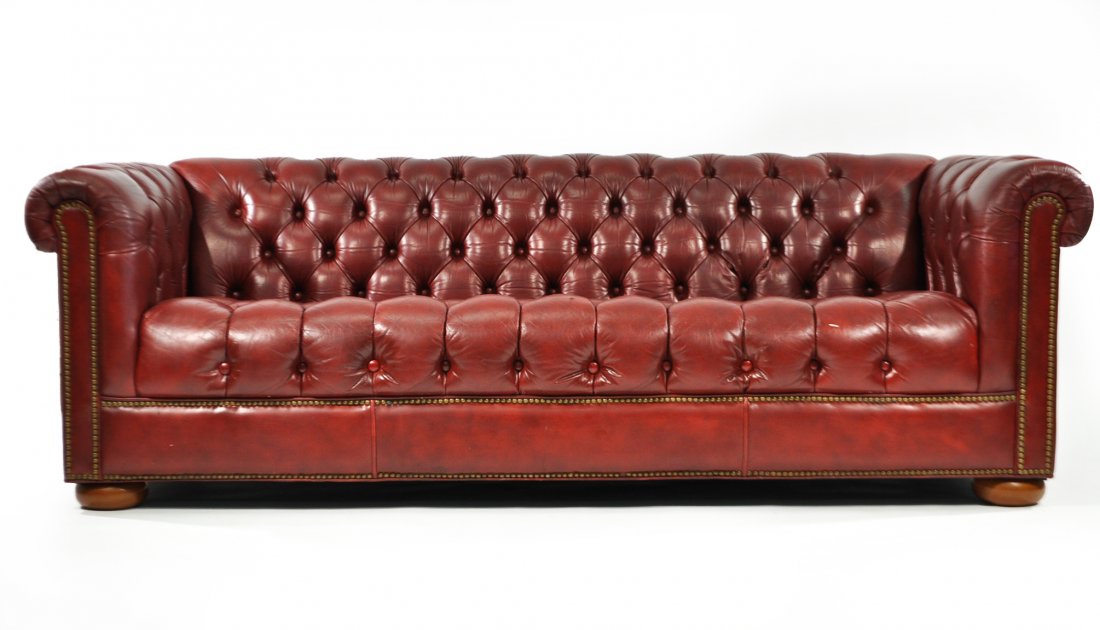 LEATHER TUFTED CHESTERFIELD SOFA: 1970s, tufted leather, brass studs and stained wood, unsignedDimensions: H 28" x W 84" x D 36"Condition: leather & foam are soft. One minor hole in seat. Nice vintage condition.