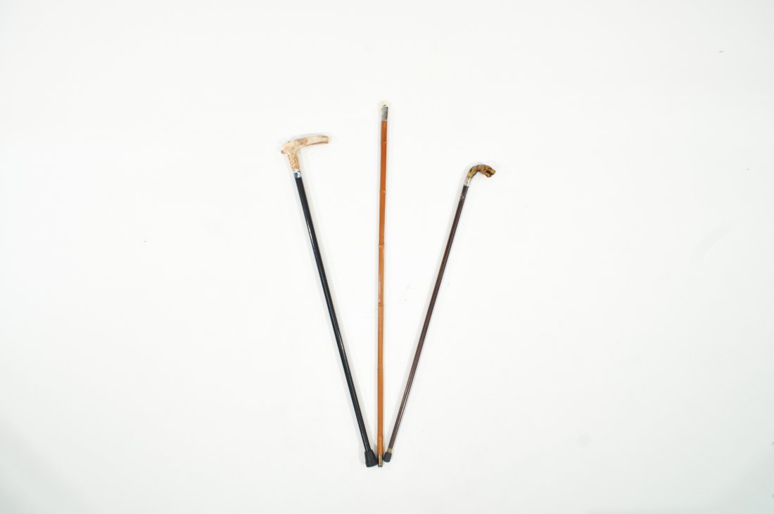 GROUPING OF CARVED FIGURAL CANES: Including sterling silver and carved horn tiger handle, sterling silver and bamboo with carved bone scull, carved antler alligator handle.Dimensions: L 36"Condition: Missing eye in tiger