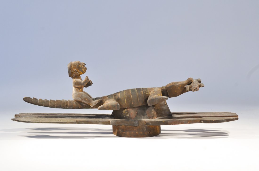 AN IJO WATER SPIRIT MASK, PLANK HEADDRESS: A composite mask of four parts, the head piece is an upturned face with spears projecting forward and machetes projecting to the rear. Attached over the face obscuring it somewhat is a female crocodil