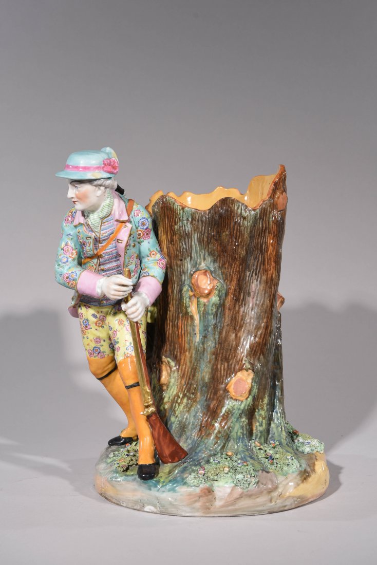 MEISSEN FIGURAL VASE OR URN: Hunter with pheasant and treestump Hand painted, markd on the bottom. Dimensions:H14"X W11.5" XD8.1/4" Condition: Old repairs with staples and additional wood molded to support the base. maybe missing