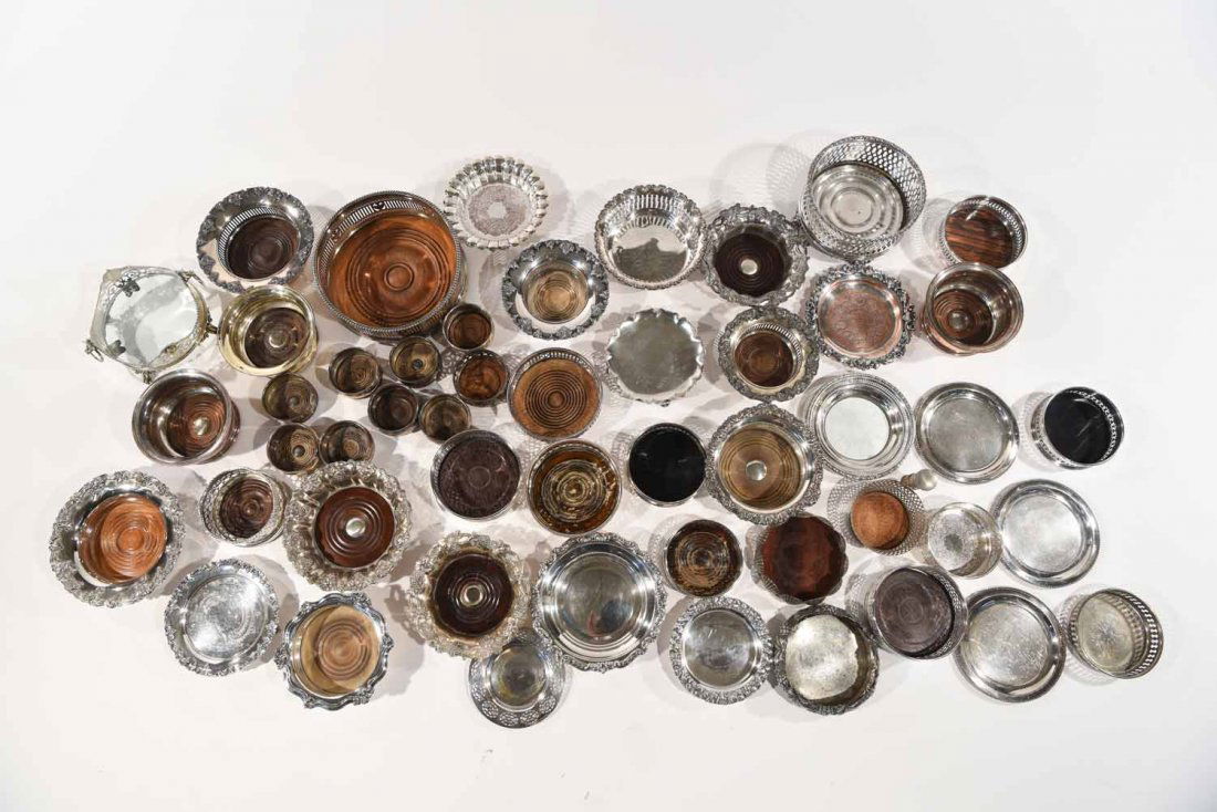 WINE COASTERS GROUPING: Dimensions: H 3" x dia 9.25" (quantity), an extensive assortment of mostly vintage silver plated American and English bottle coasters, some meant for decanters and glasses. 1900s-1960s