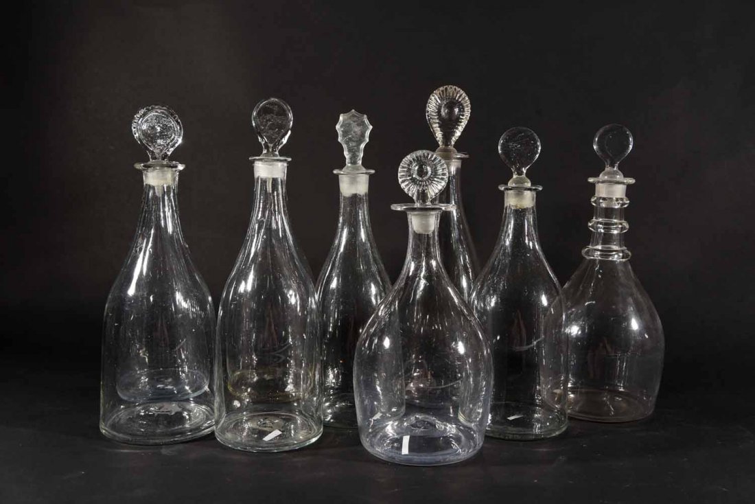 GEORGIAN WINE DECANTERS: Dimensions: Tallest H 12.25" x Dia 4", Prussian and indian club shaped clear flint glass, a three-ring neck one others plain, target and inverted pear stoppers.1750s-1790s