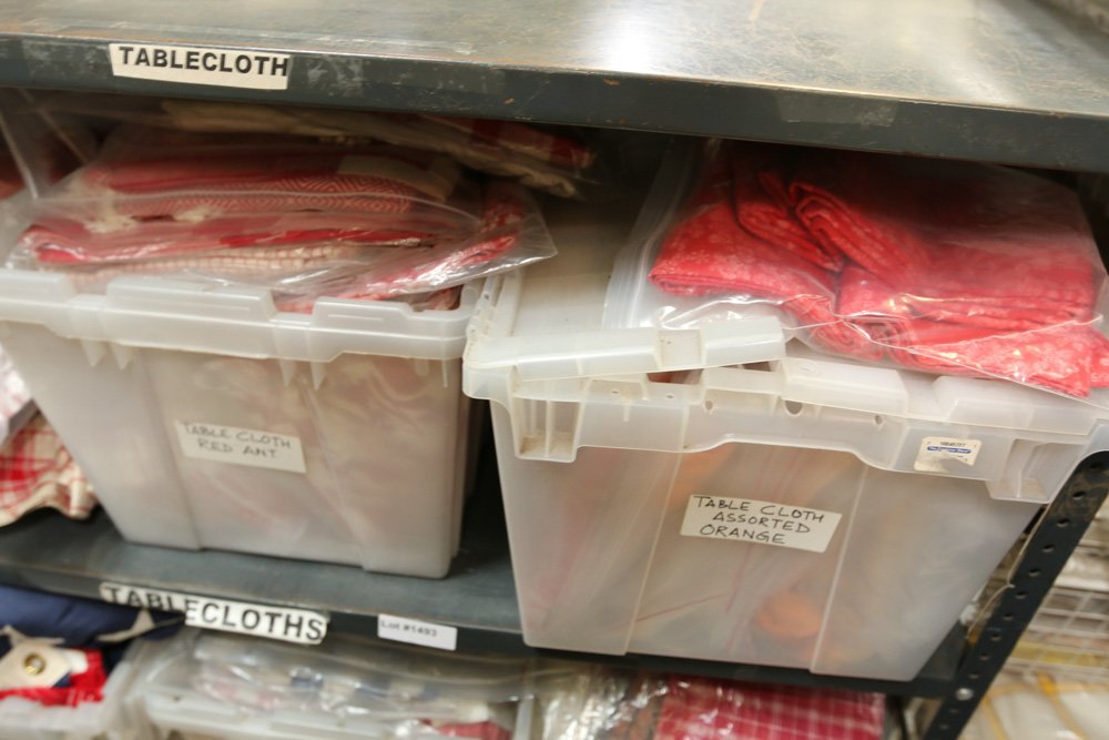 Shelf unit of table cloths incl red ,orange, and (1 of 3)