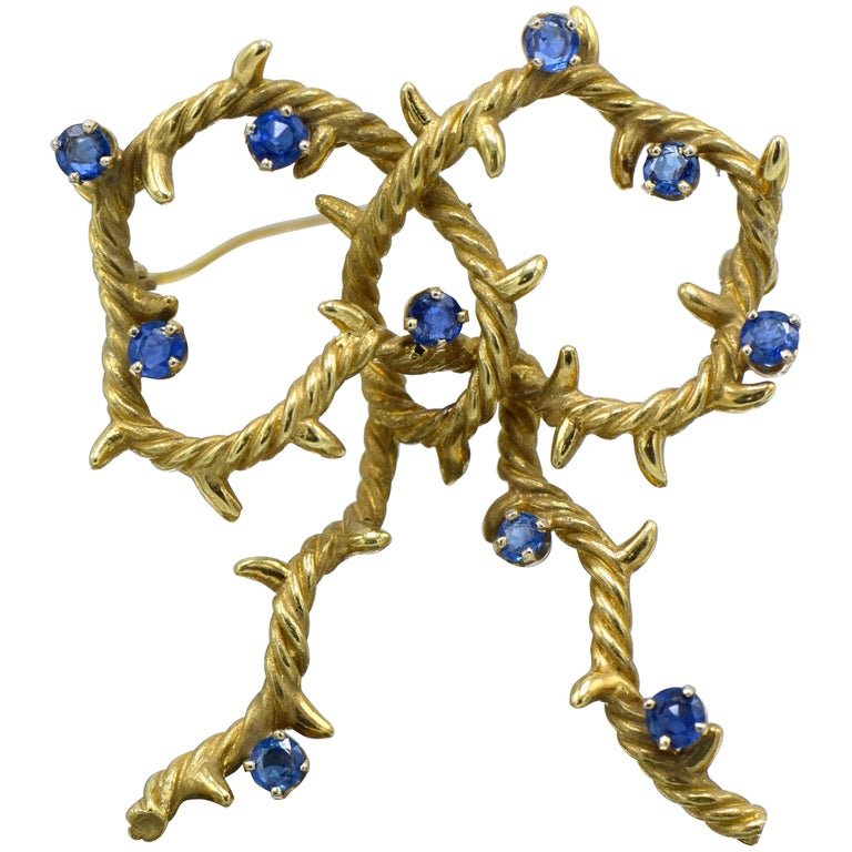 Cartier, New York 18 Karat Gold and Sapphire Bow Shaped: Cartier, New York 18K Gold and Sapphire Bow Shaped BroochThis Brooch was made in the 1970\'s by Cartier. Includes serial number 21434.