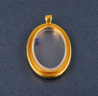 Cartier yellow gold pendant: Cartier 18K yellow gold pendant wih a lapis ball inside the glass Signed: stamped 750 serial 136104 Dimensions 1"w x 1 1/4"h Gross weight: 8.1 dwt