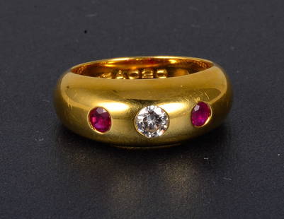 Cartier ruby and diamond ring: 18K yellow gold diamond center and flanked by two rubies. Signed: Cartier 65BA020 750 52 Dimension: 8 mm wide Gross weight: 5.2dwt Ring size: between 5 3/4 to 6