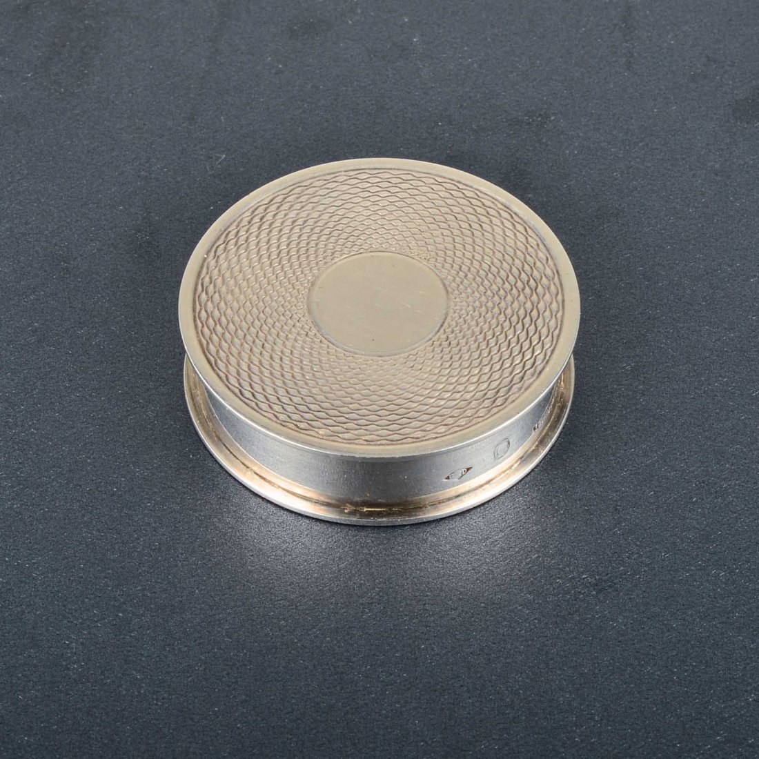 Hermes Silver Pillbox: A Hermes sterling silver round pillbox with decorative pattern. The pill box is signed Hermes Paris, Made in France, 13, and stamped with hallmarks and makers marks. The pill box measures 1 1/2" in di