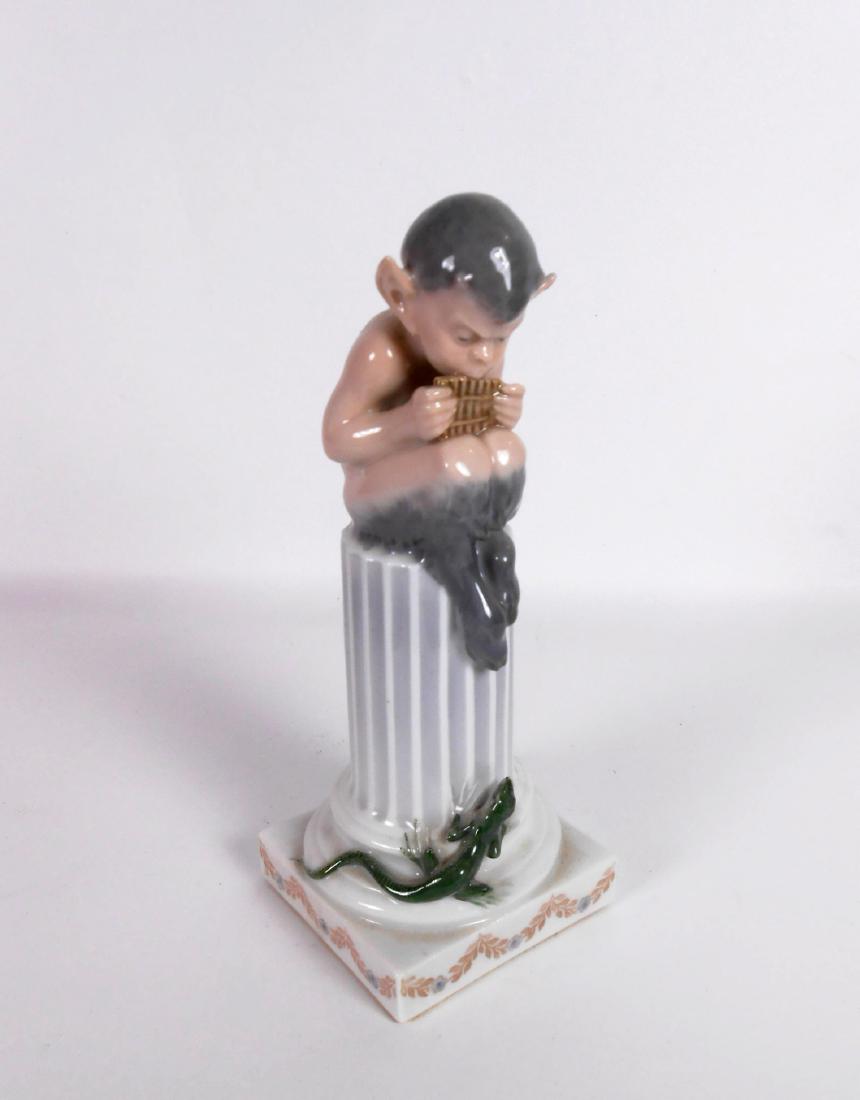 Royal Copenhagen Faun Playing A Flute: Royal Copenhagen figure of a faun seated atop a fluted column playing a flute. H. 8 1/4 inches. Perfect condition.