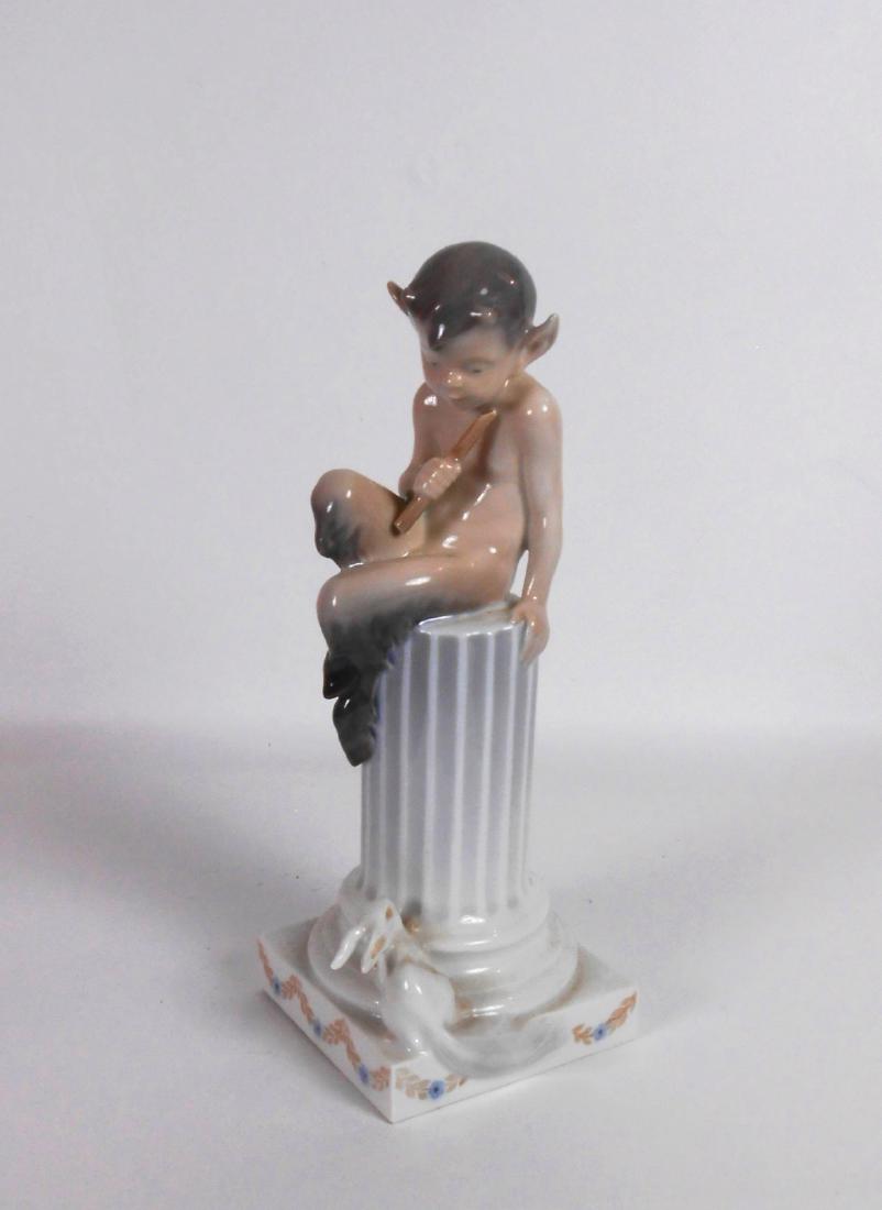 Royal Copenhagen Faun And Rabbit: Royal Copenhagen figure of a faun seated atop a fluted column holding a flute and looking down at a rabbit. H. 8 1/2 inches. Perfect condition.
