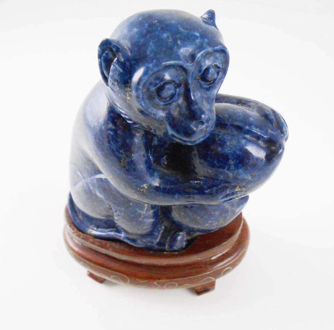 Chinese Carved Lapis Monkey: Carved lapis figure of a monkey, Chinese, holding fruits of dark blue lapis lazuli with pyrite inclusions. Mounted on a carved wood base. Minor damage to monkey's right foot. H. 4 inches (not includin