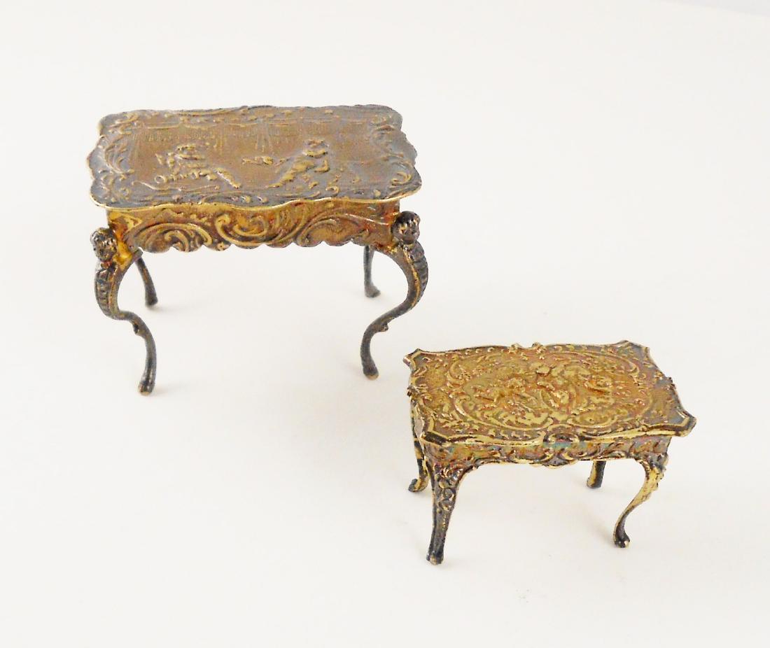 Miniature Sterling Silver & Gilt Center Tables: Two miniature sterling silver rococo-style center tables, one having a hinged top that opens to reveal a small interior compartment, both hallmarked, circa 1890-1900. The table with the hinged top has
