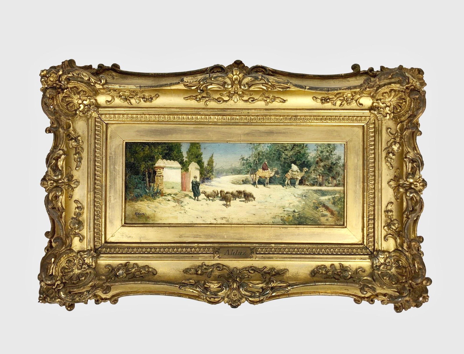 Juan Aldaz Y Sanchez (19th C.) Oil Painting: Oil painting on panel, landscape with shepherd and figures on camels, by Juan Aldaz Y Sanchez (Spanish,19th century). Signed. 3 3/4 x 9 3/4 inches. Very good condition. Original gilt frame. Provenance
