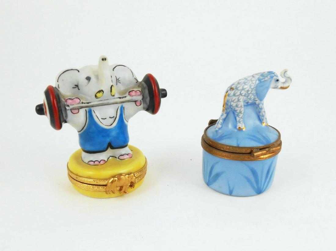 Two Vintage Limoges Trinket Boxes: Two handpainted (peint main) Limoges porcelain trinket boxes, with hinged lids. One whimsical box depicting an elephant holding barbells. H. 2 1/2 inches. No apparent damage or repairs.