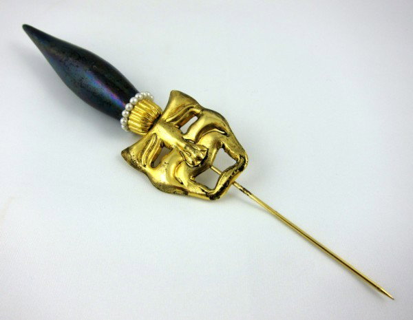 Antique Venetian Hatpin: Circa 1900 gold finish Venetian stick or hat pin with faceted crystals and mask of "tragedy". 6 1/4 inches long. A gift to the present owner by Gene Moore. Gene Moore (1910-1998) was vice-president of
