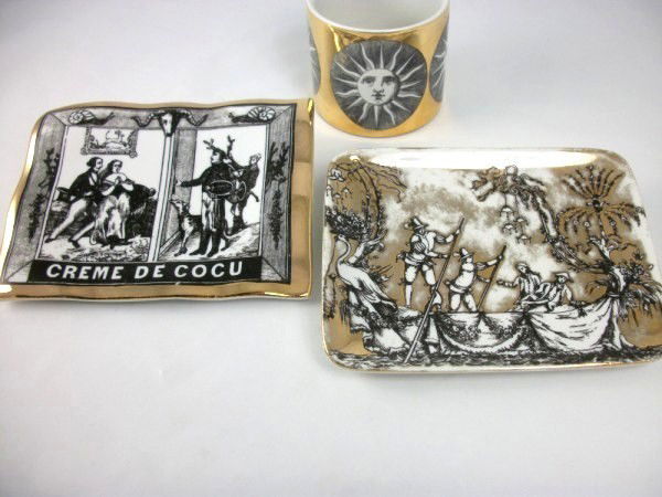 Group Of Fornasetti Transfer-Printed Items: Two small porcelain trays together with a small cup. Trays measure approximately 5 1/2 x 4 1/4 inches. Excellent condition.