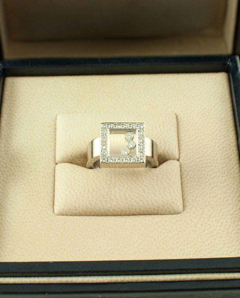 Chopard "Happy Diamonds" Ring: A "Happy Diamonds" ring by Chopard. The square-shaped compartment set with 20 diamonds and containing 3 bezel-set brilliant-cut "happy" diamonds which move freely around the square. Diamonds approx. 0