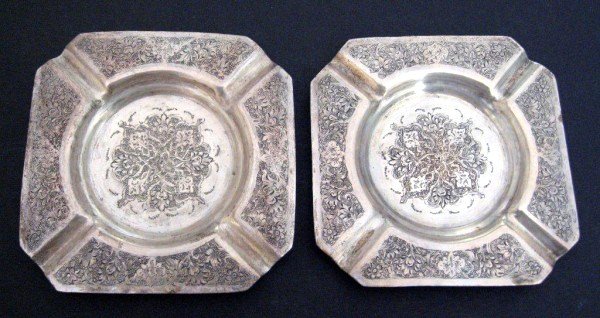 Vintage Persian Engraved Silver Ashtrays: Two mid-century hand-hammered Persian silver ashtrays, each heavily engraved with flowers and scrolling foliage. Persian hallmarks. Silver standard 875. Total weight: 5.24 oz.