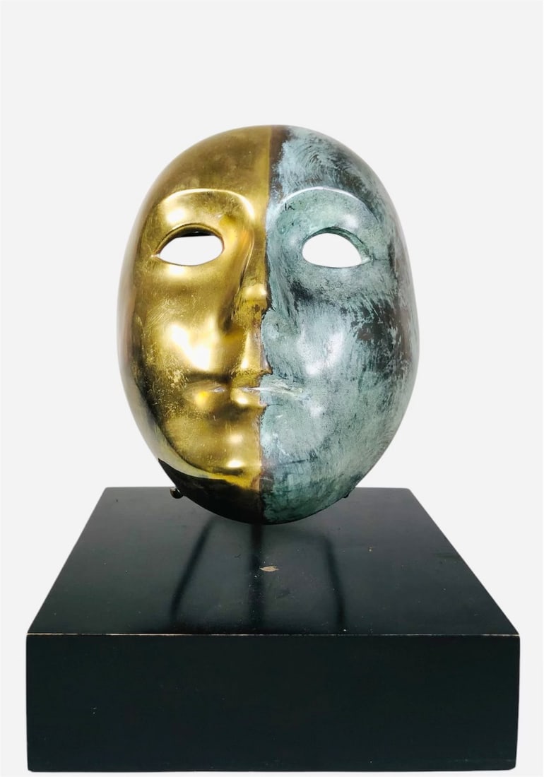 Dual-Patinated Bronze Mask On Stand: Stylized dual-patinated bronze mask on stand, possibly signed on the interior of the mask. H. 10 inches W. 7 inches. Very good condition overall. Provenance: Formerly in the private collection of Mr. 