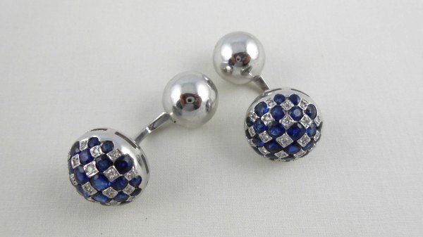 18 KT Sapphire & Diamond Cufflinks: Pair of 18 KT white gold domed button cuff links. Featuring a blue sapphire and diamond checker board pattern. Fitted with balls and posts. 42 diamonds weighing approximately 0.50 ct. 48 natural blue 