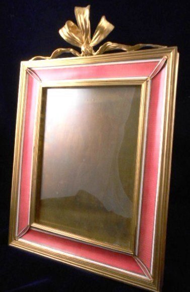Gilt Bronze & Guilloche Enamel Picture Frame: Exceptional quality French gilt bronze table frame, having borders of white enamel and pink guilloche enamel, surmounted by a gilt-bronze knotted ribbon. Marked France. Circa 1900-1920. Overall dimens